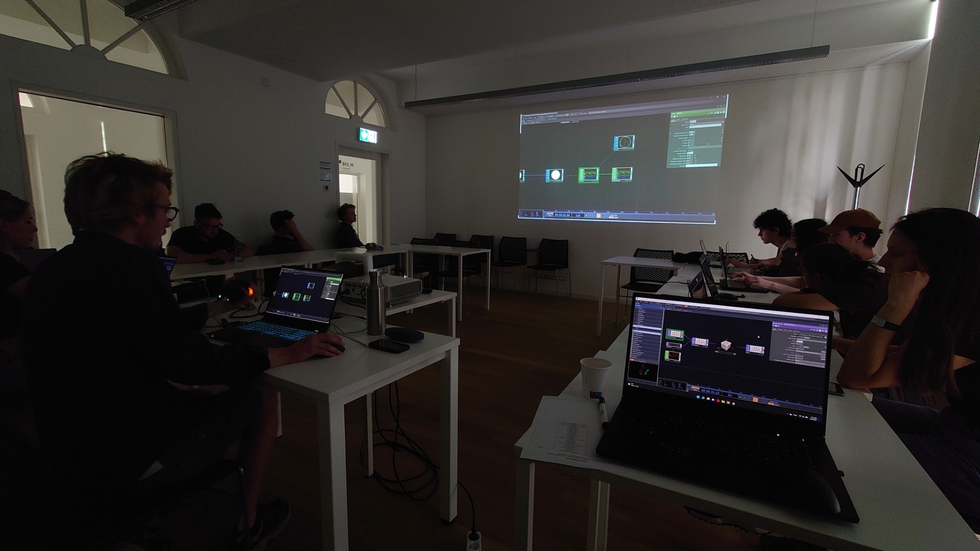 Participants gathered around a shared TouchDesigner project